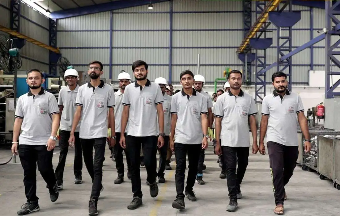 Workers standing on the production floor wearing uniforms