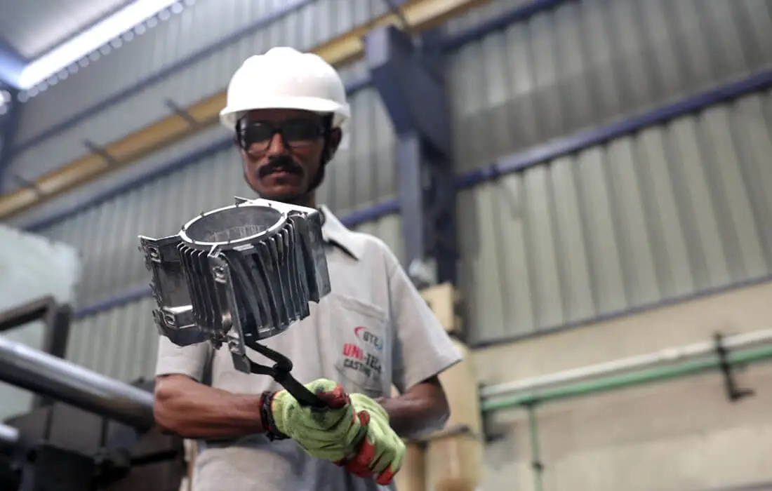 Worker holding a finished aluminum die-cast component