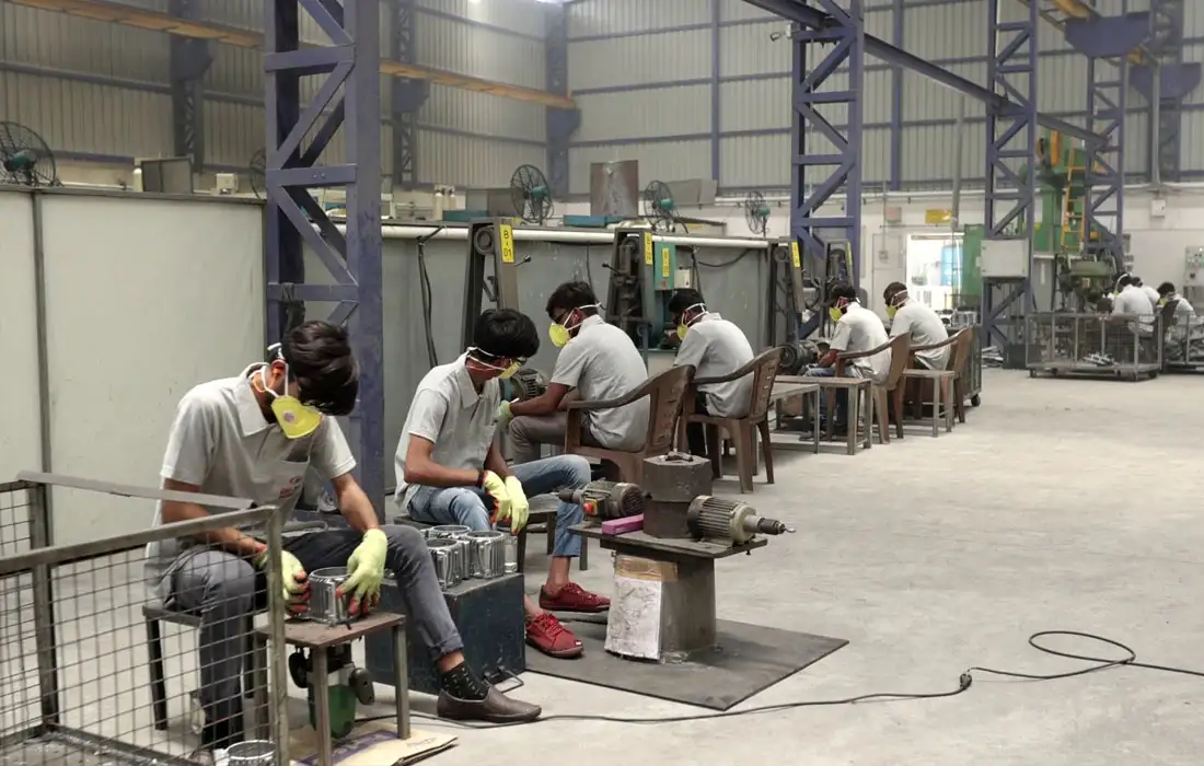 Workers operating machining workstations on a factory floor