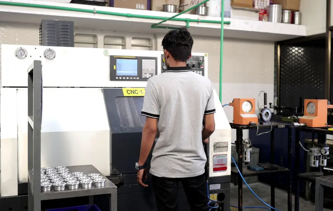 Vertical CNC machine producing precision-machined metal parts