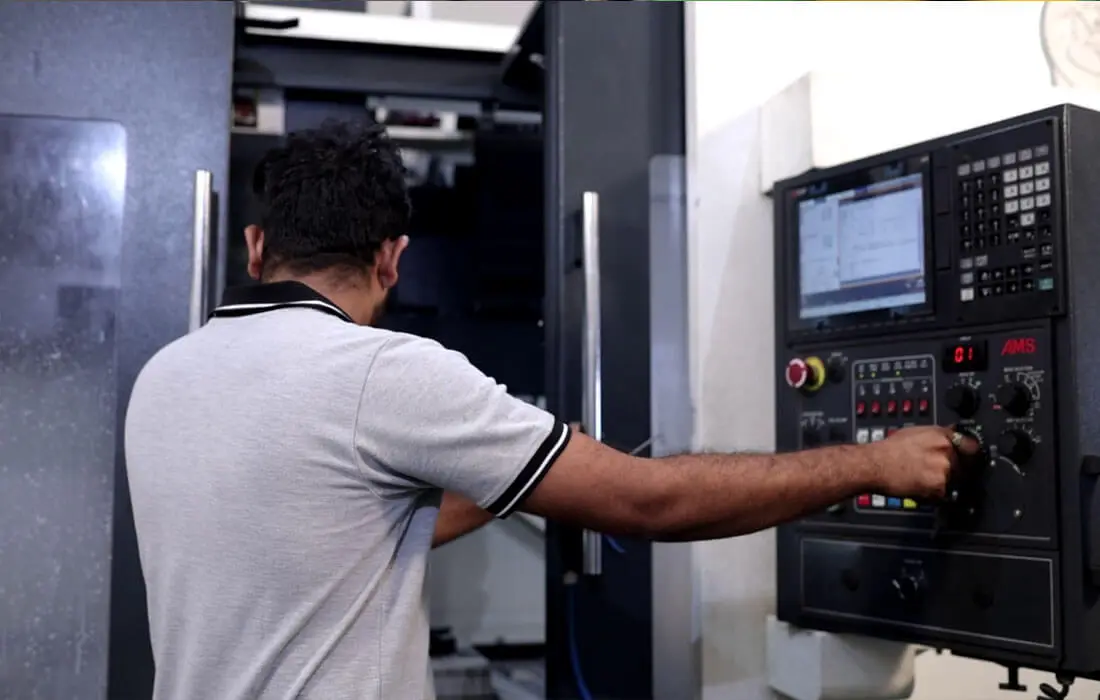 CNC machine operator monitoring machining parameters