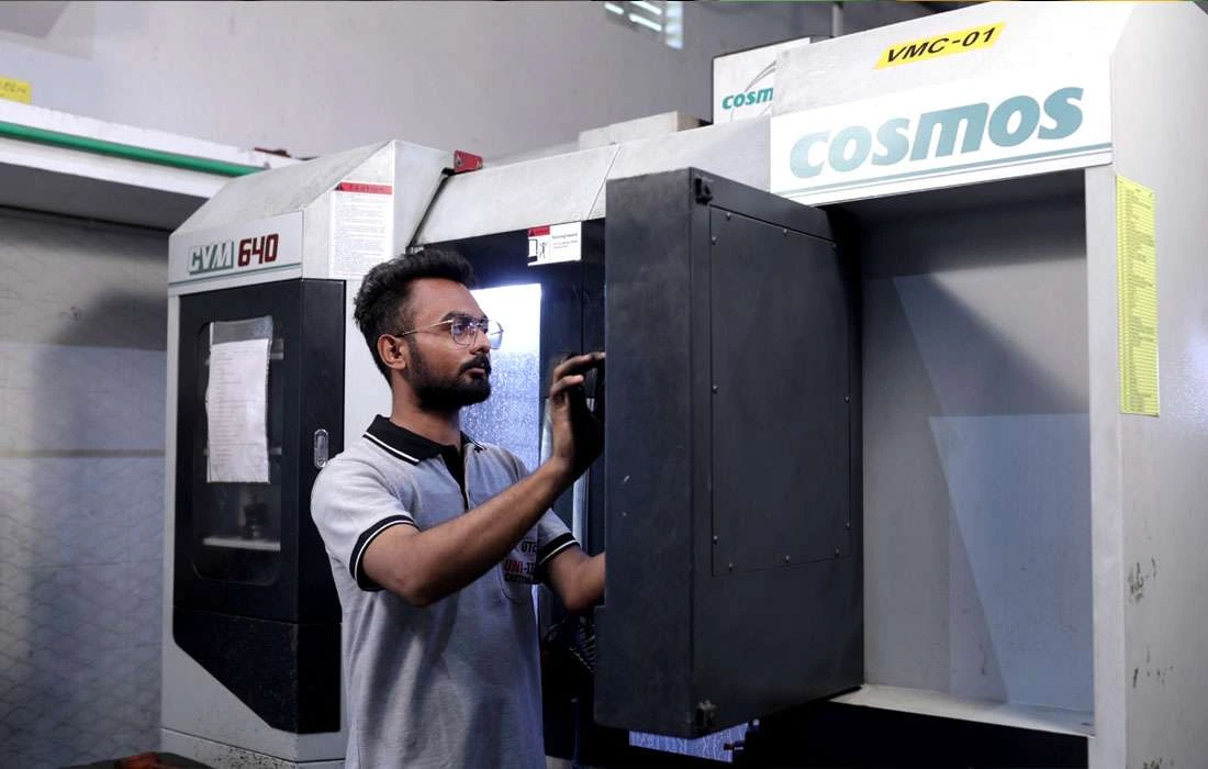 Technician inspecting CNC machining center during routine maintenance