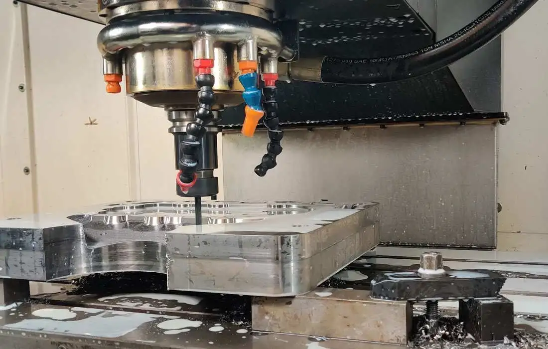 CNC milling machine cutting metal block