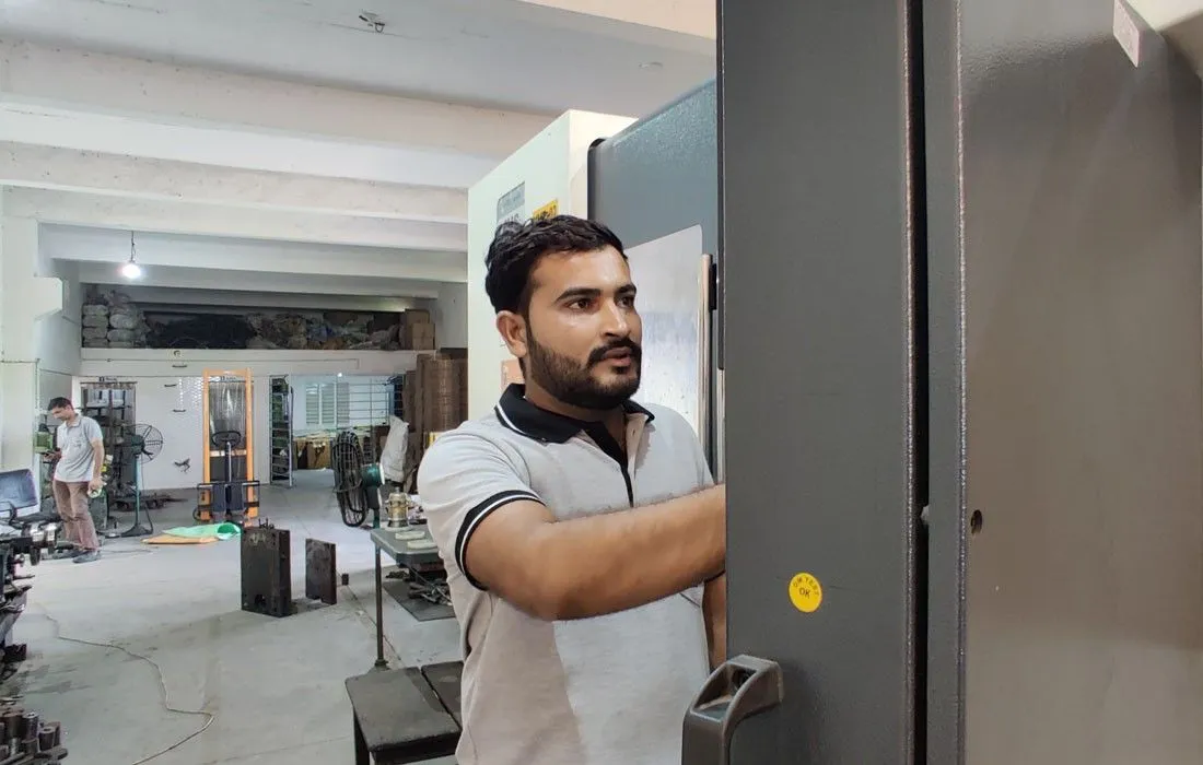 CNC machine operator loading metal component