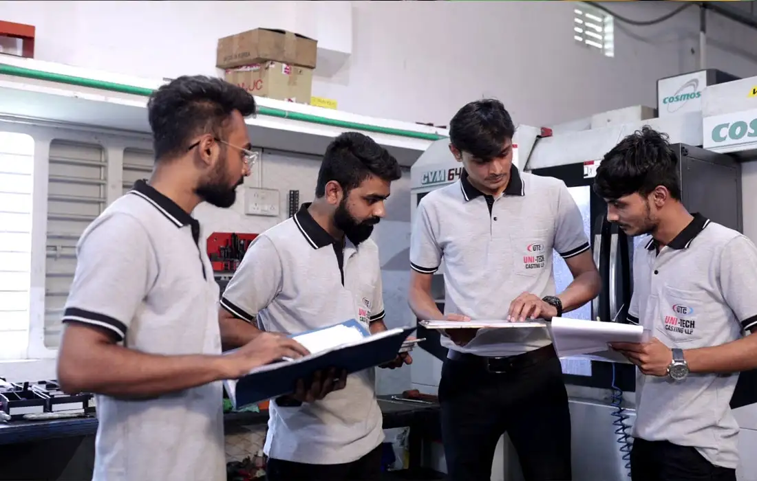 Quality control team reviewing production checklist and specifications