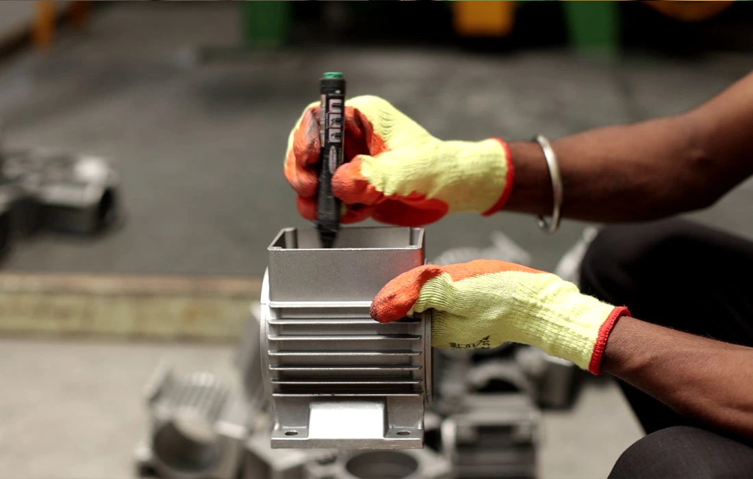 Worker measuring aluminum die-cast part